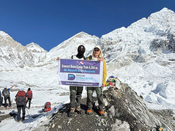 Trekkers at Everest Base Camp with snow-covered mountains