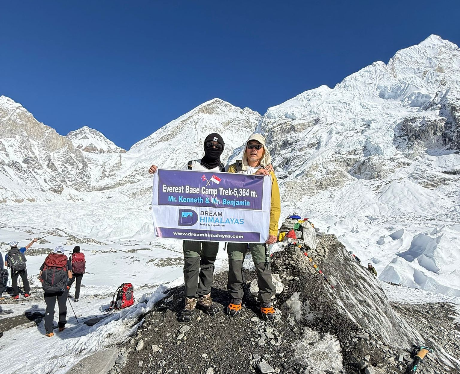 Trekkers at Everest Base Camp with snow-covered mountains