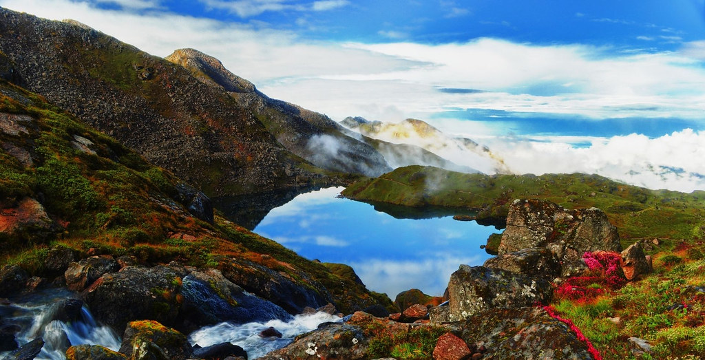 Gosaikunda Lake surrounded by green hills and Himalayan mountains in Nepal