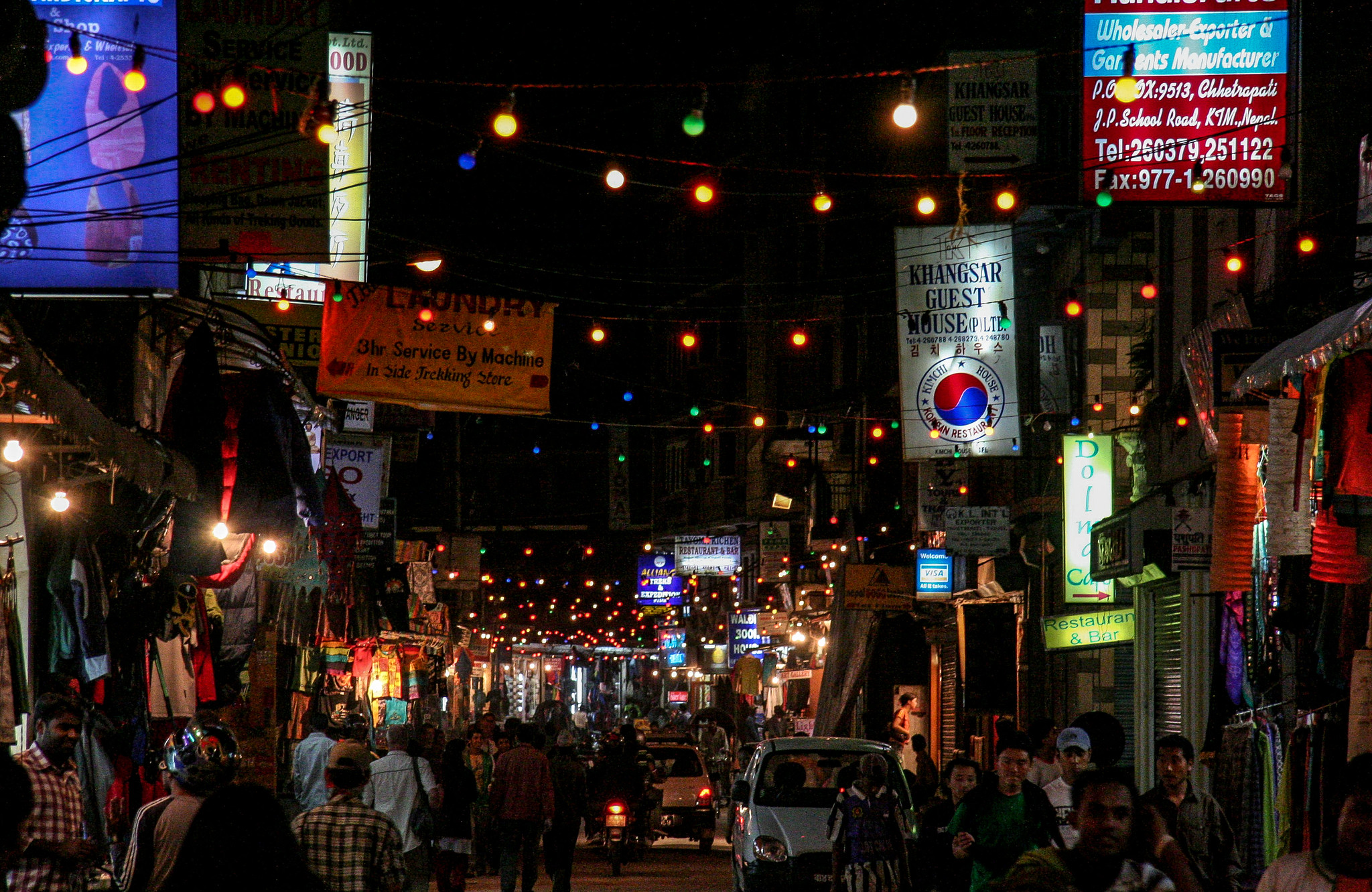 Thamel Kathmandu street at night with colorful lights, shops, and pedestrians